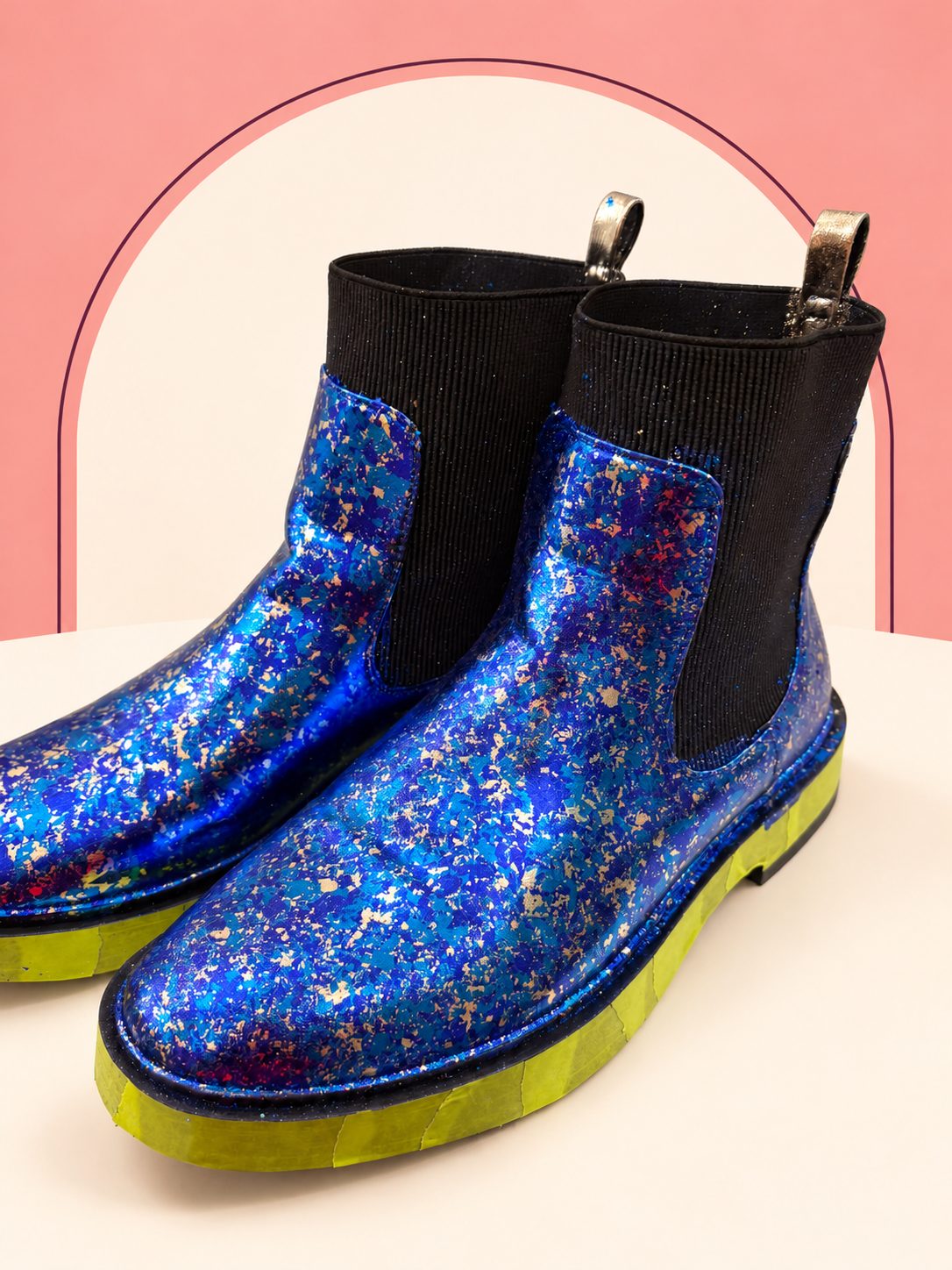 The same ankle boots after blue and metallic foil-leaf decoration, with black elastic panels and masking tape still in place.